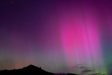 Otago, Palmerston 'daki Puketapu dağının üzerinde pembe kirişli Aurora Australis. Palmerston, Yeni Zelanda 'nın Güney Adası' nda yer almaktadır.. 