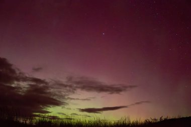 Mayıs 2024 'te Yeni Zelanda' nın güney adasında Aurora Australis 'in kırmızı ve sarı gökyüzü Matakaea (Shag Point) üzerinde parıldıyor..