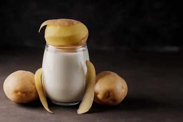 Aardappelmelk Glas Aardappelschillen Lactosevrije Plantaardige Melk Rauwe Aardappelen Een Donkere — Stockfoto