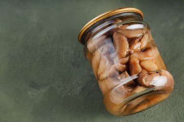 Yeşil arka planda kavanozdaki konserve mantarlar. Sürdürülebilir yaşam tarzı konsepti. Boşluğu kopyala