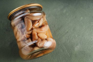 Yeşil arka planda kavanozdaki konserve mantarlar. Sürdürülebilir yaşam tarzı konsepti. Boşluğu kopyala