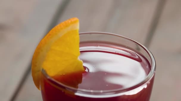 Gelas Anggur Dengan Irisan Oranye Berputar Atas Meja Kayu Minuman — Stok Video