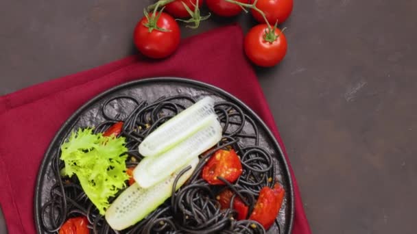 스파게티에 야채를 파스타 스파게티에 배경에 오징어 잉크를 곁들인 요리를 위에서 — 비디오