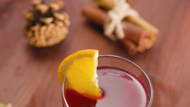 一杯带橙片的覆膜葡萄酒 木桌上涂满了葡萄酒和配料 手持射击 — 图库视频影像