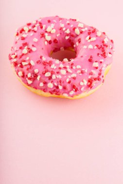 Pembe pastel arka planda pembe çörekler. Bir tatlı pembe çörek. Üst Manzara. Boşluğu kopyala