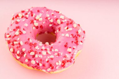 Pembe arka planda renkli serpiştirilmiş donut. Renkli tatlı kavramı