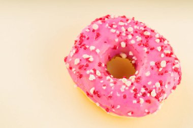 Sarı arka planda çok renkli serpiştirilmiş tatlı pembe donut. Renkli tatlı tatlı