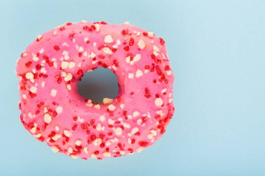 Pembe şekerli tatlı donut. Mavi arka planda nefis jöleli donut. Üst Manzara. Boşluğu kopyala