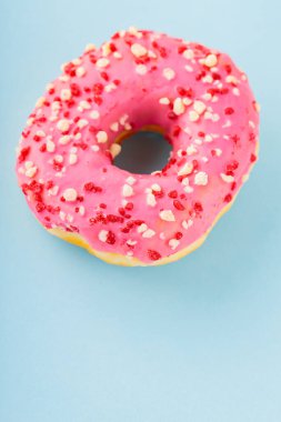 Pembe şekerli tatlı donut. Mavi arka planda nefis jöleli donut. Üst Manzara. Boşluğu kopyala