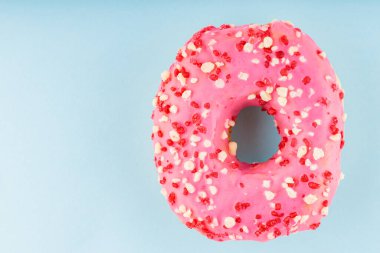 Pembe şekerli tatlı donut. Mavi arka planda nefis jöleli donut. Üst Manzara. Boşluğu kopyala