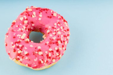 Pembe şekerli tatlı donut. Mavi arka planda nefis jöleli donut. Üst Manzara. Boşluğu kopyala