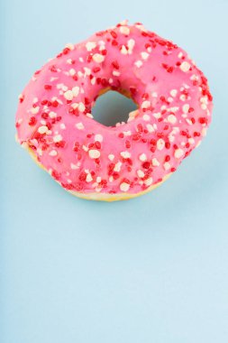 Pembe şekerli tatlı donut. Mavi arka planda nefis jöleli donut. Üst Manzara. Boşluğu kopyala