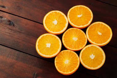 Halves of oranges on a wooden boards. Juicy orange halves for making juice on a wooden table. Copy space
