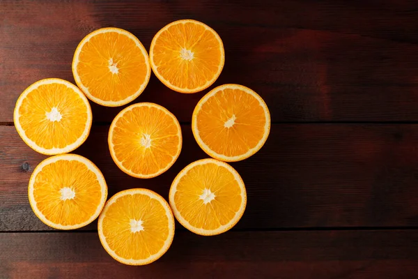 Halves of oranges on a wooden boards. Juicy orange halves for making juice on a wooden table. Copy space