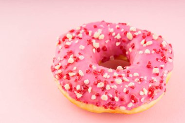 Pembe arka planda renkli serpiştirilmiş donut. Renkli tatlı kavramı