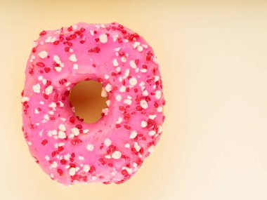 Sarı arka planda çok renkli serpiştirilmiş tatlı pembe donut. Renkli tatlı tatlı