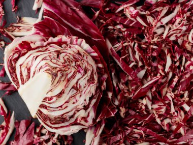 Chopped radicchio salad on slate board. Radicchio on a dark background. Healthy vegan food concept. Top view