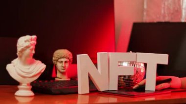 NFT inscription and artificial arm. Non-Fungible token lettering in neon light. Crypto art concept. Tilt up camera shot