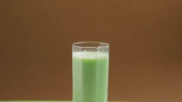 倒入一杯健康的开心果奶 用开心果在亚麻布餐巾上的高杯中制成乳糖免费牛奶 — 图库视频影像