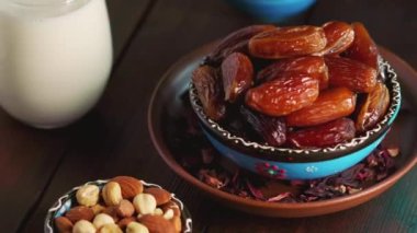 Kurumuş hurma, fındık ve süt dolu bir kase. Ramazan Kareem ve iftar müslüman yemeği. Dönen kamera görüntüsü
