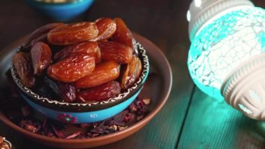 Kurumuş hurma, fındık ve süt dolu bir kase. Ramazan Kareem ve iftar müslüman yemeği. Dönen kamera görüntüsü