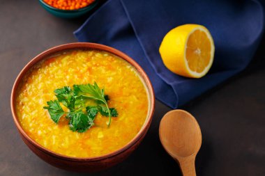 Mavi keten peçeteye bir kase mercimek çorbası. Taze maydanozlu kırmızı mercimek çorbası. Geleneksel Orta Doğu yemekleri. Kapat.