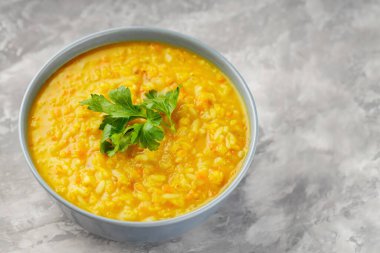 Gri arka planda kırmızı mercimek çorbası. Bir kase mercimek çorbası. Geleneksel Orta Doğu yemekleri