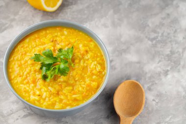 Gri arka planda kırmızı mercimek çorbası. Bir kase mercimek çorbası. Geleneksel Orta Doğu yemekleri