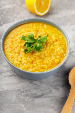 Gri arka planda kırmızı mercimek çorbası. Bir kase mercimek çorbası. Geleneksel Orta Doğu yemekleri