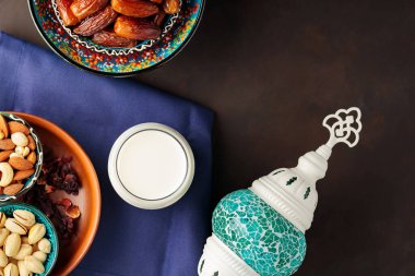 Kurumuş hurma, fındık ve süt. Ramazan Kareem ve iftar müslüman yemekleri ve Türk lambası. Ramazan konsepti. Üst görünüm