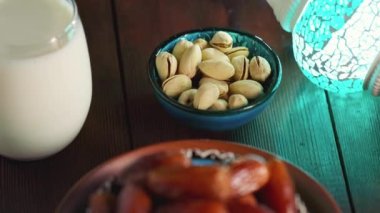 Tahtada kurutulmuş hurma, fındık ve süt. Ramazan Kareem ve iftar müslüman yemeği. İslam dini ve ramazan kavramı. Kamera hareketini aşağı eğ