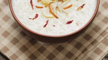 Kil kasede servis edilen sütlaç. Ahşap arka planda fındıklı Hint pilavı. Popüler Ramazan yemeği. Kamera hareketini yukarı kaldır