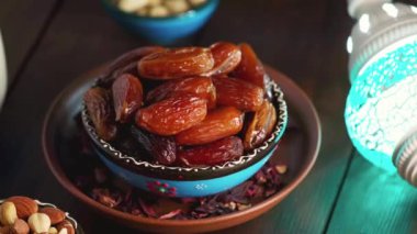 Kurumuş hurma, fındık ve süt dolu bir kase. Ramazan Kareem ve iftar müslüman yemeği. Dönen kamera görüntüsü