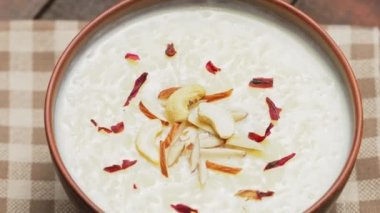 Çamur kasesinde fındıklı Hint kheer sütlacı. Yakından sütlaçlı kase. Geleneksel iftar yemeği. Bum!