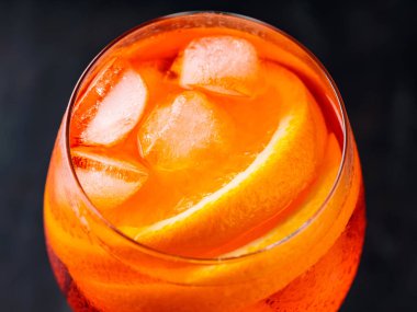 Portakallı ve buzlu Aperol Spritz kokteyli. Siyah arka planda turuncu alkol kokteyli. Kapat.