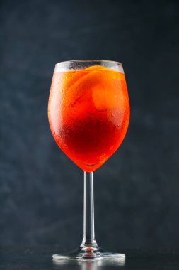 Karanlık arka planda Aperol Spritz kokteyli. Portakallı ve buzlu Aperol Spritz kokteyli. Yaz ferahlatıcı içecek