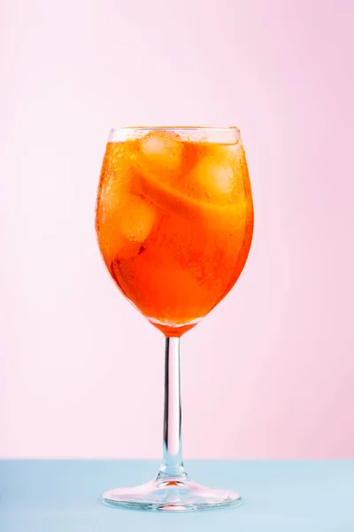 Aperol Spritz鸡尾酒在一个粉色蓝色背景的杯子里 鸡尾酒尾Aperol Spritz与橙子和冰块 靠近点 — 图库照片