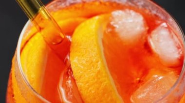 Aperol Spritz kokteyli, yakın çekim. Portakallı ve buzlu Aperol Spritz kokteyli. Geleneksel İtalyan aperatif kokteyli. El kamerasıyla.