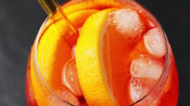 Aperol Spritz kokteyli, yakın çekim. Portakallı ve buzlu Aperol Spritz kokteyli. Geleneksel İtalyan aperatif kokteyli. El kamerasıyla.