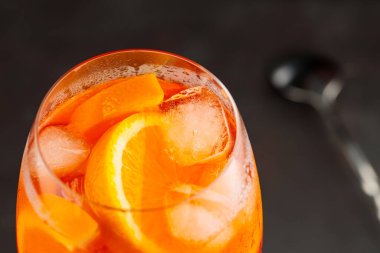 Portakallı ve buzlu Aperol Spritz kokteyli. Siyah arka planda turuncu alkol kokteyli. Kapat.
