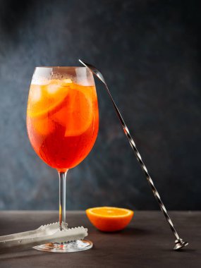 Aperol sprey kokteyli ve arka planda çelik çubuk aletleri. Kokteyl Aperol Spritz ve portakal dilimi. Boşluğu kopyala