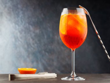 Aperol sprey kokteyli ve arka planda çelik çubuk aletleri. Kokteyl Aperol Spritz ve portakal dilimi. Boşluğu kopyala
