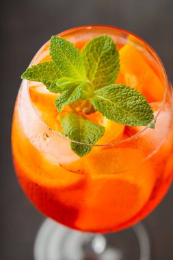 Klasik İtalyan aperatifi Aperol Spritz kokteyli koyu arkaplanda bir dilim portakal. Geleneksel İtalyan aperatif kokteyli konsepti. Kapat.