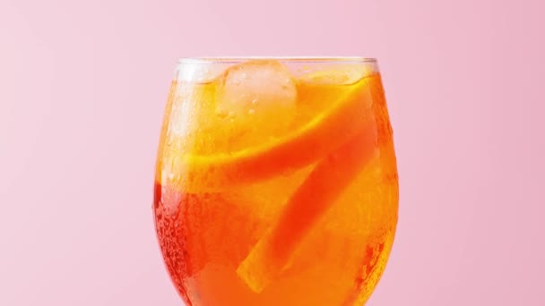 아페르 칵테일은 분홍색 배경에 유리로 있습니다 Cocktail Aperol Spritz 오렌지와 — 비디오