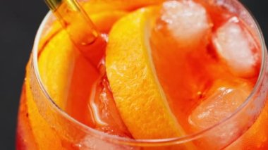 Aperol Spritz kokteyli, yakın çekim. Portakallı ve buzlu Aperol Spritz kokteyli. Geleneksel İtalyan aperatif kokteyli. El kamerasıyla.