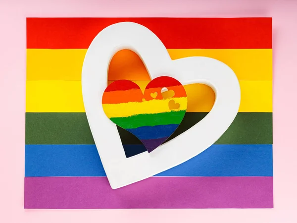 Rainbow heart and white heart on LGBT Pride flag. LGBT equal rights movement and gender equality concept. Close up
