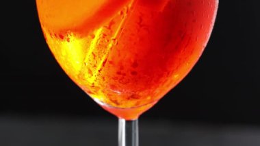 Kokteyl Aperol Spritz, yakın plan. Siyah arka planda bir bardak Aperol Spritz. Eğil.