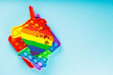 Renkli gökkuşağı kalbi mavi arka planda oyuncak. Gökkuşağı renginde kalp ve oyuncak anti-stres. Gurur ayı konsepti. Boşluğu kopyala