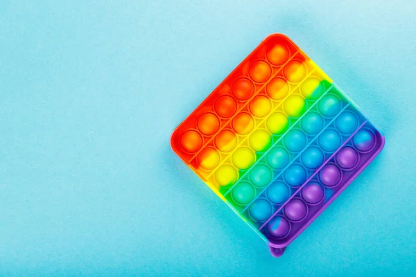 stock image Pop it fidget sensory toy on blue background. LGBT Pride month concept. Top view. Copy space