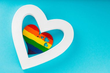 Mavi arka planda gökkuşağı kalbi ve beyaz kalp. LGBT Gurur Ayı konsepti. Üst Manzara. Boşluğu kopyala